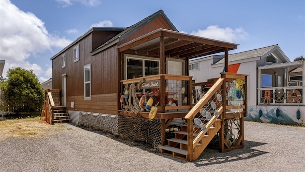 Ein Holzhaus mit einer Veranda und einer Treppe zum Eingang.