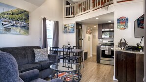 Eine moderne Wohnung mit Essbereich, Küche und einem Balkon mit Geländer.