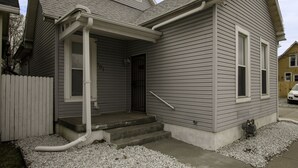 A two-story house with a front porch, a small front yard, and a driveway. - Experience Indianapolis living close to Lucas Oil Stadium (Indianapolis)