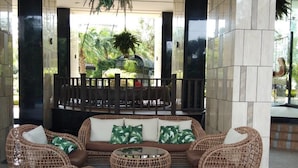 A lobby with wicker furniture, a central seating area, and a hanging plant. - Riviera Pattaya Beach (Pattaya)