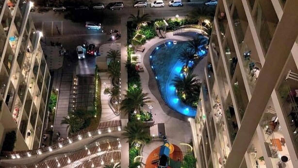 Un edificio moderno con piscina sul tetto, area giochi per bambini e giardino a forma di cuore.