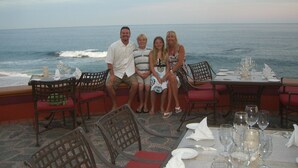 A family dining at a table with a view of the ocean.