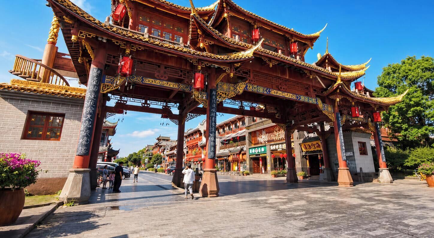 A traditional Chinese gate with ornate architecture, a paved walkway, and surrounding buildings.