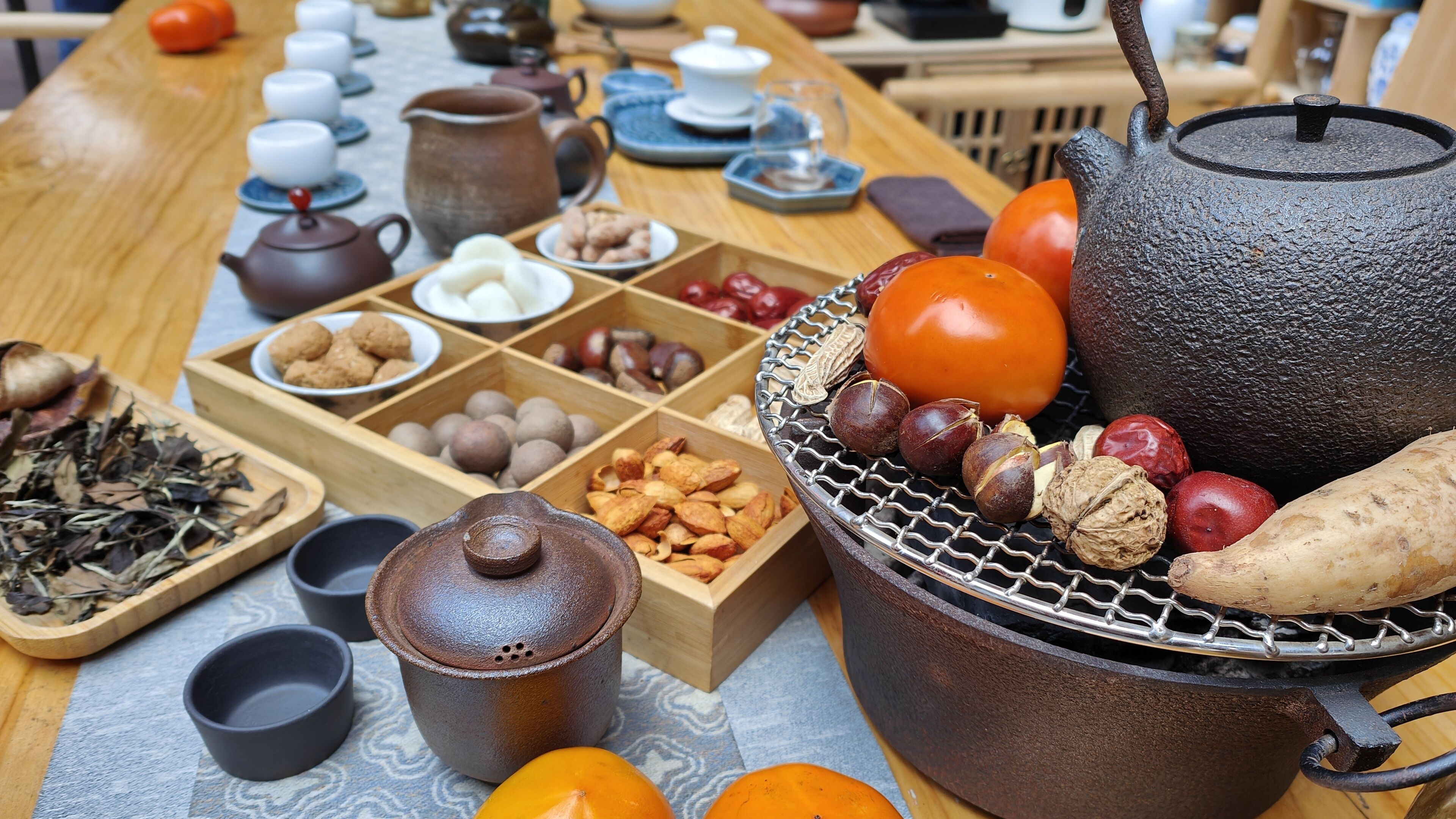 A traditional tea setting with various tea utensils and snacks.