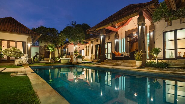 A poolside area with a clear pool, outdoor seating, and a building with large windows and a tiled roof. - 7BR-Last Minute Deal 50%+ OFF!! Nusa Dua (Bali)