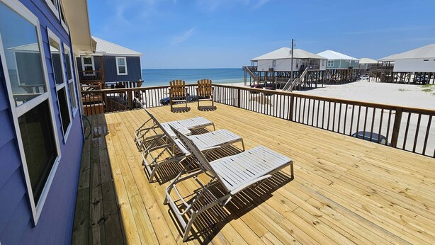 A wooden deck with lounge chairs and a view of the beach and ocean. - enJoy | gulfside, great price, open starting 8/8 (Dauphin Island)