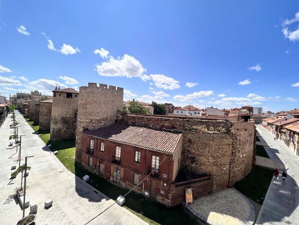 Un edificio histórico con un patio, una torre grande y un camino empedrado.