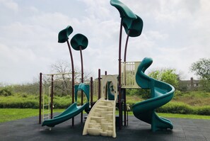 Ein Spielplatz mit Rutschen und Klettergerüsten.