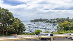 Boats docked in a serene marina surrounded by lush greenery and rolling hills.