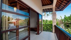 A balcony with a view of tropical vegetation and a building in the background. - Magical Estate, Walk to Seminyak Beach (Seminyak)