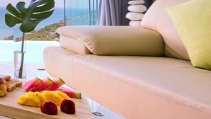 A modern living room with a beige sofa, a glass coffee table, and a view of the ocean. - Karpe Diem: 5BR with Twin Infinity Pools (Ko Samui)