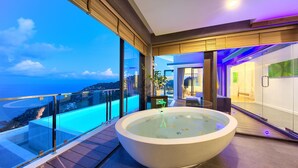 A modern bathroom with a large bathtub, a glass-enclosed shower area, and a view of the ocean. - Karpe Diem: 5BR with Twin Infinity Pools (Ko Samui)