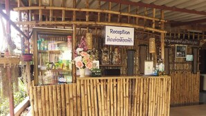 A reception area with a bamboo structure, a sign reading "Reception", and a "TIP BOX" sign. - Ban Kiang Fah Resort Chongmek (Sirindhorn)