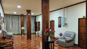 A spacious lobby with a patterned tile floor, wooden pillars, and seating areas. - Ban Kiang Fah Resort Chongmek (Sirindhorn)