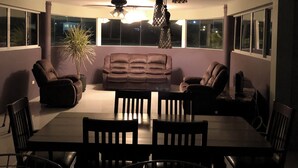 Una sala de estar moderna con un sofá, sillas y una mesa de comedor.
