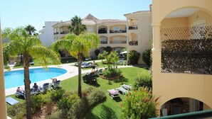 A resort with a swimming pool, palm trees, and lounge chairs. - Walk to beach/marina, pool view, aircon, wifi, parking. Ideal Families/Groups. (Vilamoura)