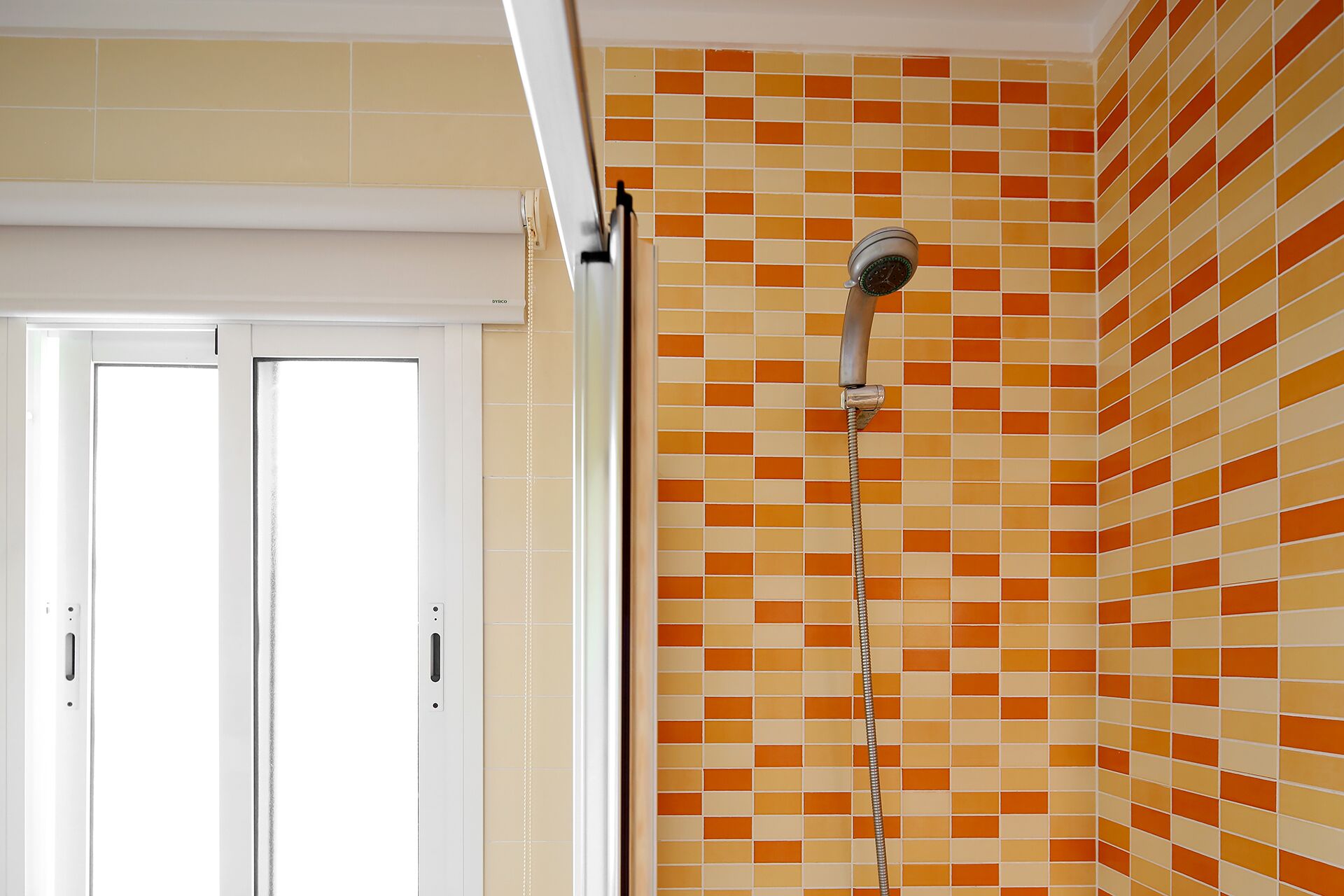 Ein Badezimmer mit Dusche, gefliesten Wänden und einer Tür.