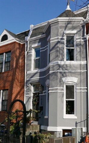 A two-story building with a grey facade and white trim, featuring a brick section on the left. - Stylish & Modern Apt  Shaw PKING! (Washington)