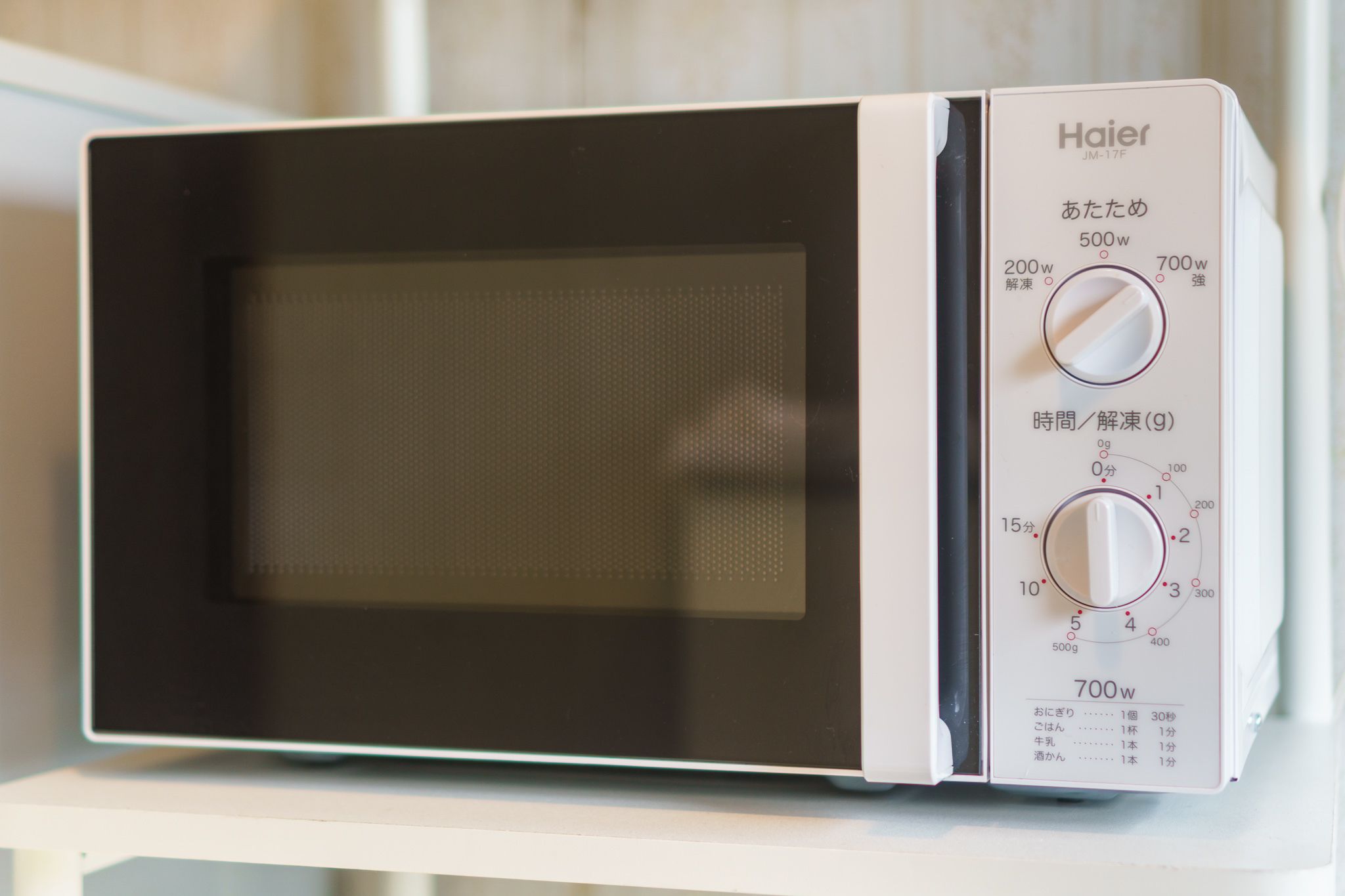 A Haier microwave oven with two power settings (200W and 700W) and a timer dial.