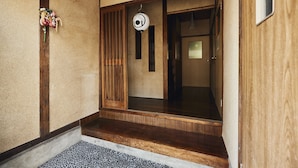 Una entrada japonesa tradicional con puertas correderas de madera y un pequeño porche.