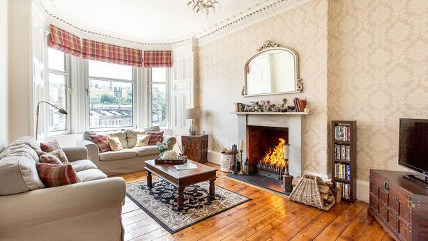 A living room with a fireplace, sofas, a coffee table, and a television.