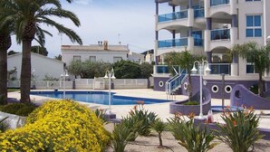 A modern hotel with a pool, palm trees, and a well-maintained garden. - Beautiful apartment for 4 people with pool, A/C, WIFI, TV and balcony (Ulldecona)