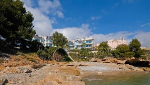 A coastal area with rocky terrain, clear water, and buildings with balconies. - Beautiful apartment for 4 people with pool, A/C, WIFI, TV and balcony (Ulldecona)