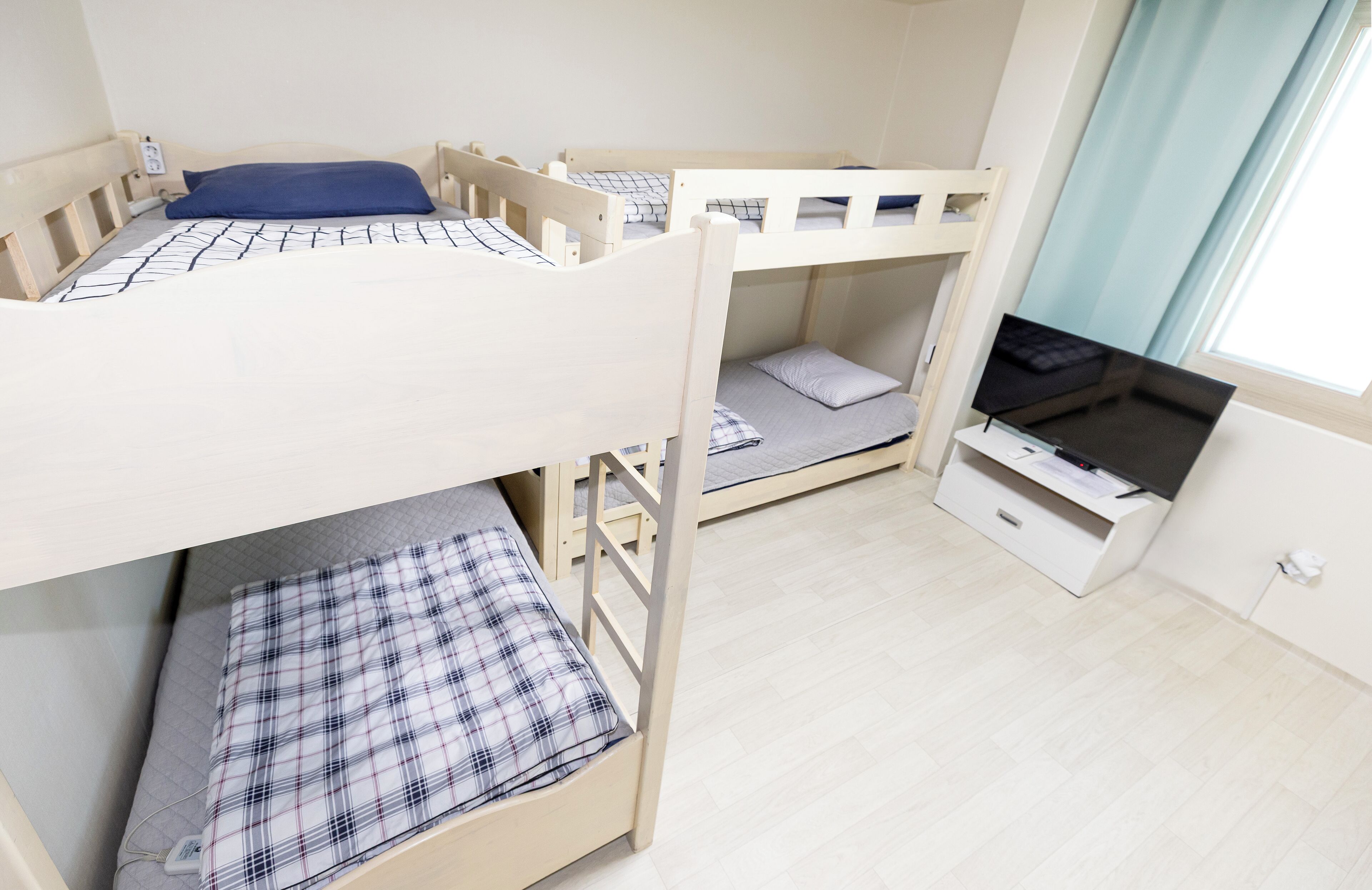 Dormitorio con literas, escritorio y ventana.