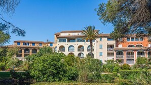 Un hôtel à plusieurs étages doté d’une cour intérieure où se trouve un bassin orné de nénuphars.