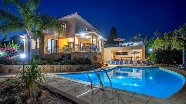 A two-story house with a swimming pool, outdoor seating, and a well-lit balcony. - Superb Villa in Coral Bay Paphos, with Half Cost of the HEATED POOL Nov-Mar 26 (Paphos (Pafos))