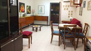 Un saló amb zona de menjador, mobles de fusta, televisió i decoració penjada a la paret.