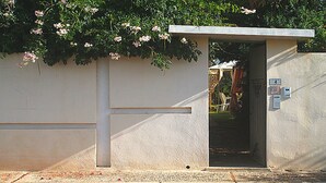 Petit espai de servei tancat amb una porta, una placa de número i una caixa de correu penjada a la paret.