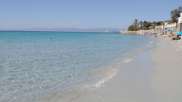 Una platja amb aigua turquesa cristal·lina i sorra daurada.