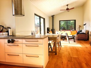 Eine moderne Küche mit Kochinsel, großen Fenstern und einem Essbereich mit Billardtisch.