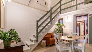 Eine Treppe mit weißen Stufen und grünen Geländern, die zu einer oberen Etage führt.