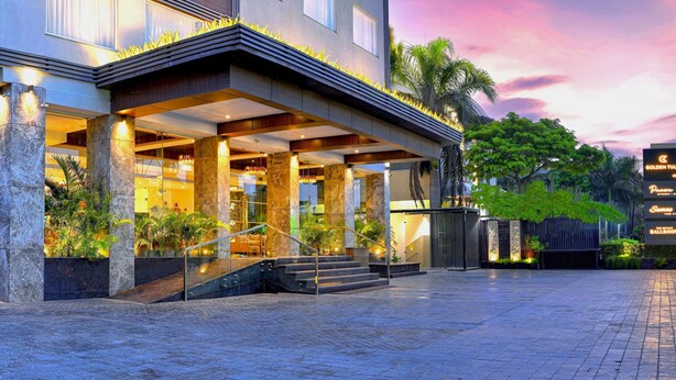 L’entrée d’un hôtel, avec un espace extérieur abrité, des portes vitrées et une enseigne indiquant « Golden Tulip ».