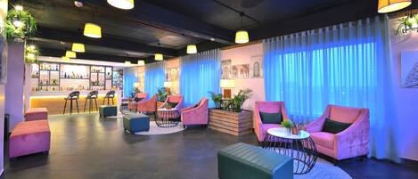 Un espace lounge moderne comprenant des sièges, un bar et des éléments décoratifs.