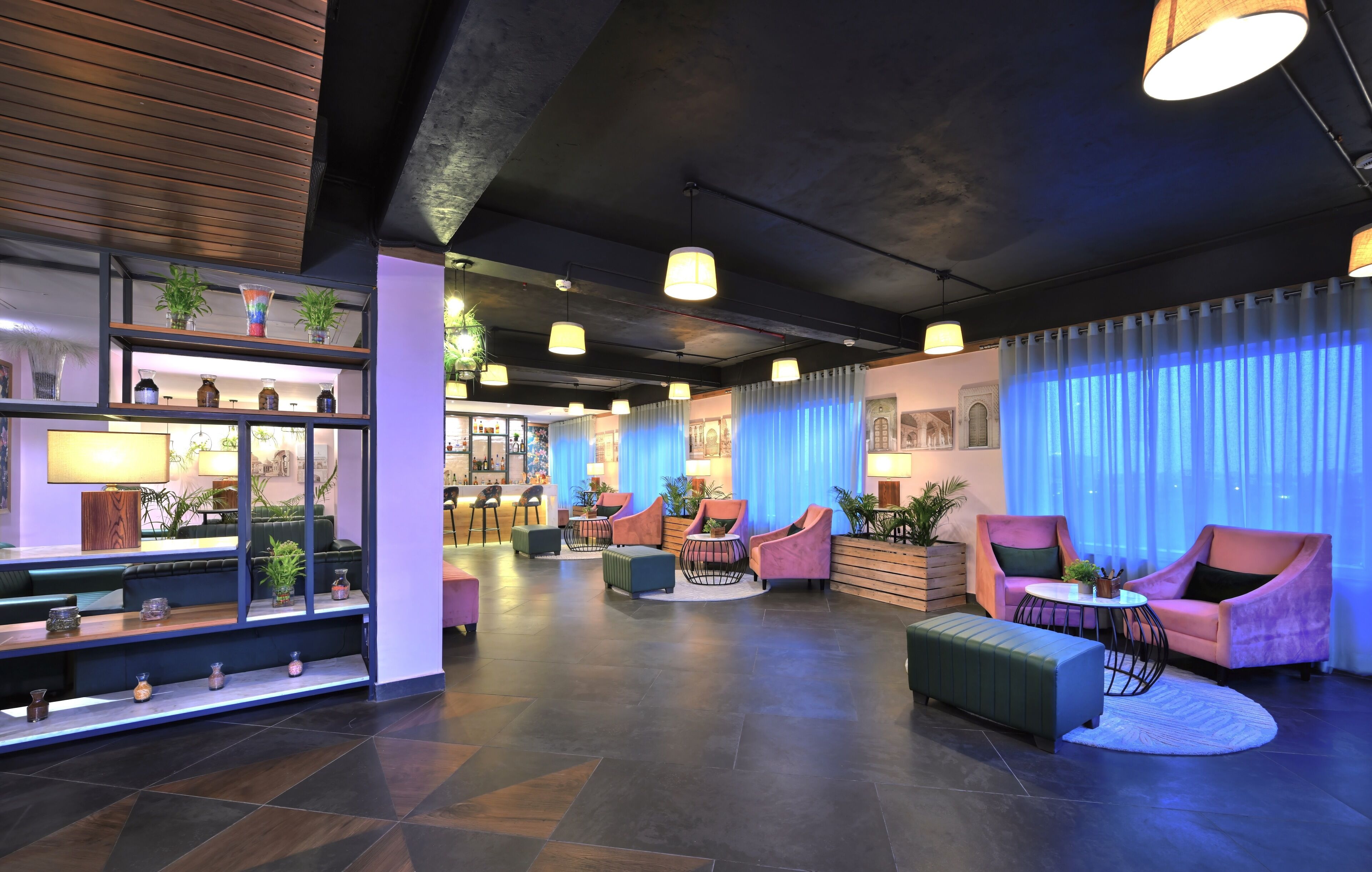 A modern lobby with a reception desk, seating area, and a variety of plants.