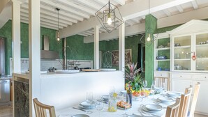 Una cocina moderna con armarios blancos, una isla central e iluminación colgante.