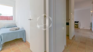 Ein Zimmer mit einem Bett, einem Fenster und einer Tür zu einem weiteren Raum.