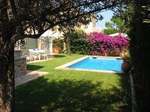 A backyard with a swimming pool, a lawn, and a patio area with chairs. - Private villa with pool in Calella, 7min-walk to beach (Palafrugell)