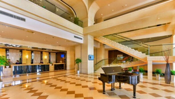 A spacious lobby with a grand piano, a reception desk, and a staircase leading to an upper level. - Xiedu Hangchen International Hotel (Chengdu)