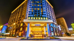 A multi-story hotel with a prominent entrance and illuminated signage. - Xiedu Hangchen International Hotel (Chengdu)