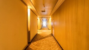 A long, narrow hotel corridor with wooden walls and carpeted floors. - Xiedu Hangchen International Hotel (Chengdu)