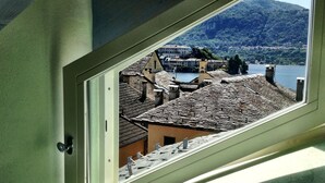 Une vue à travers une fenêtre sur une ville, avec des bâtiments et une montagne en arrière-plan.