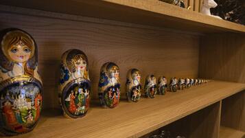 Une étagère en bois où sont exposées une rangée de poupées russes (matriochkas) peintes avec de fins détails.
