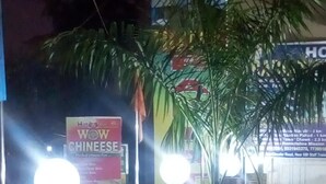 A nighttime view of a hotel entrance with illuminated signs and a paved walkway. - Hotel Radiation (Deoghar)