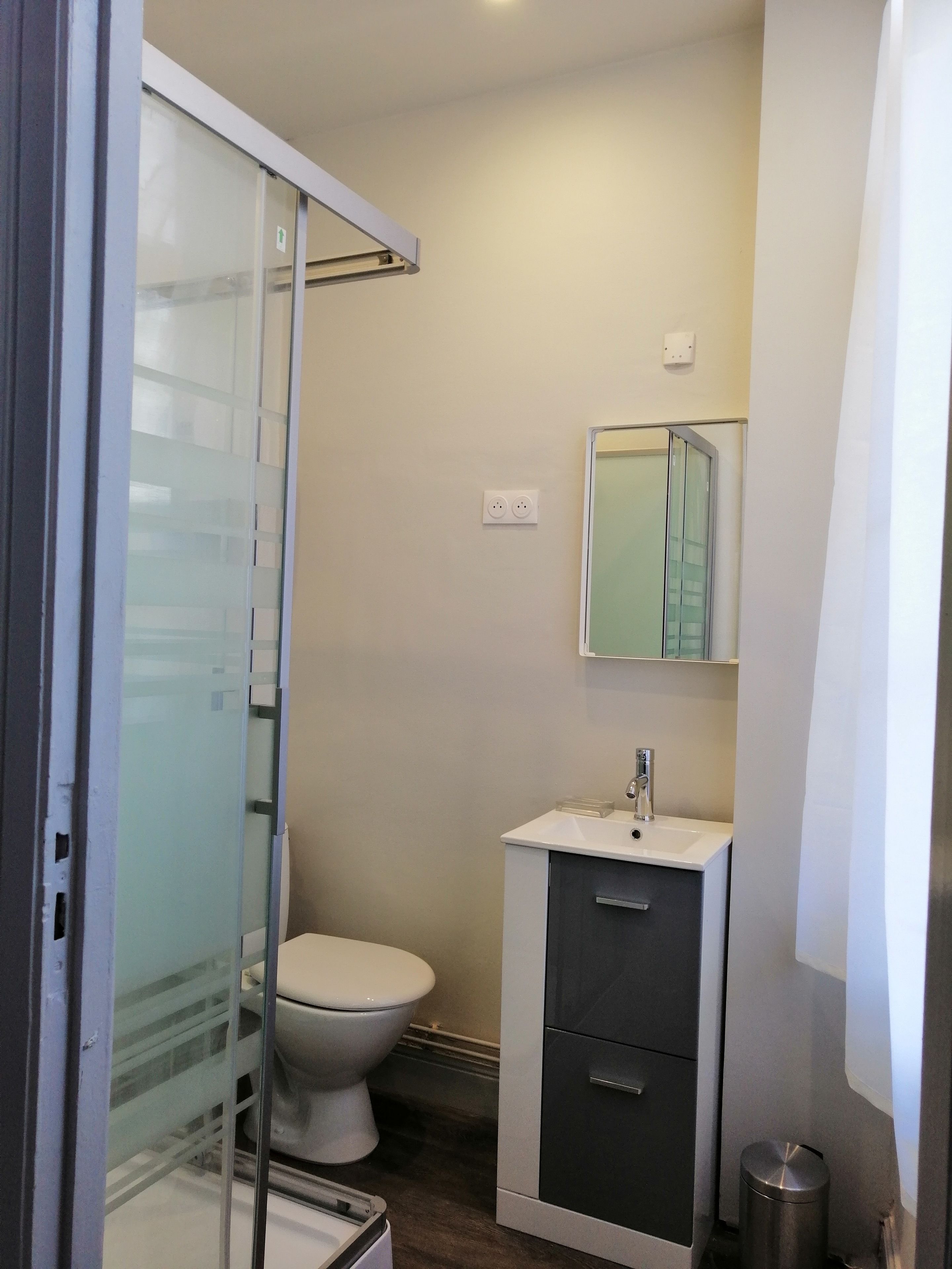 Un baño pequeño con inodoro, lavamanos y espejo.