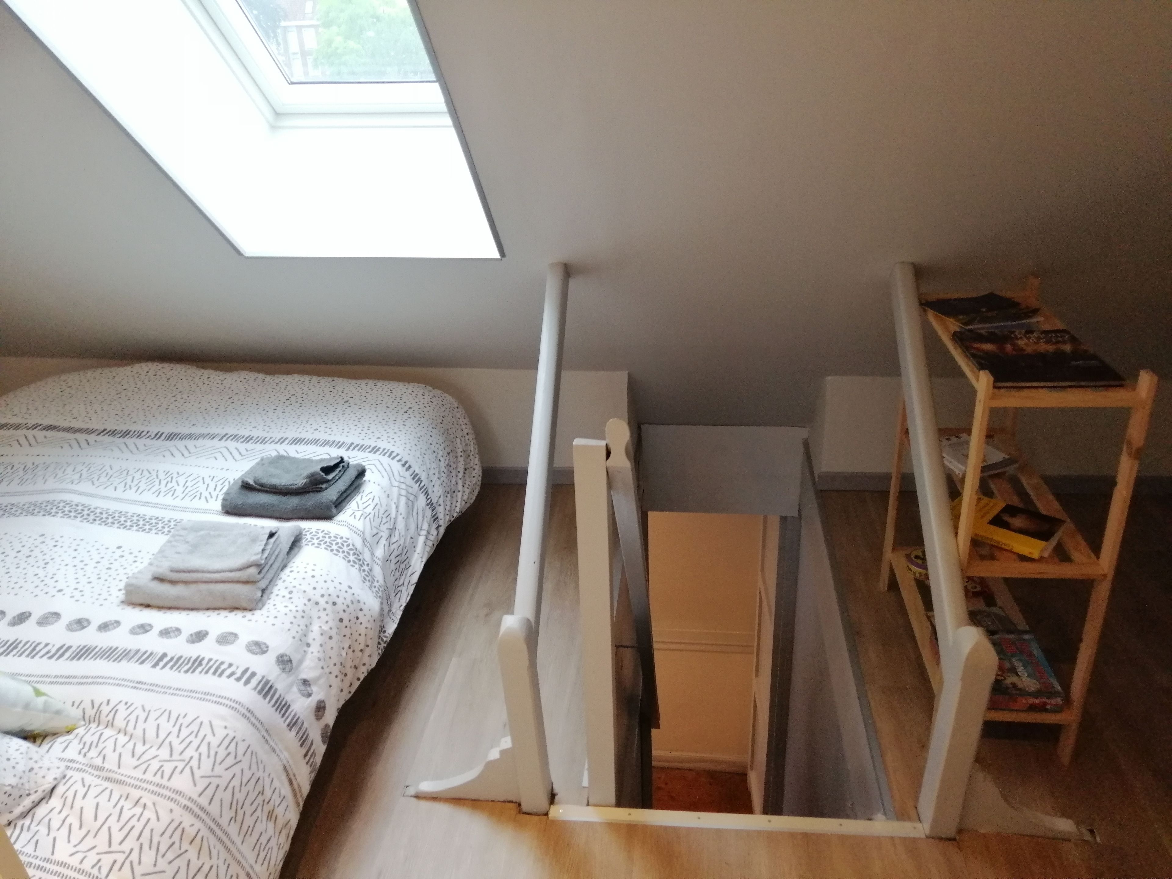 Um quarto com uma cama, uma escrivaninha e uma estante de livros.