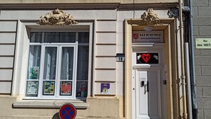 Un edificio con una puerta blanca que dice "B&B MY ART HOUSE" y una ventana con varios carteles.